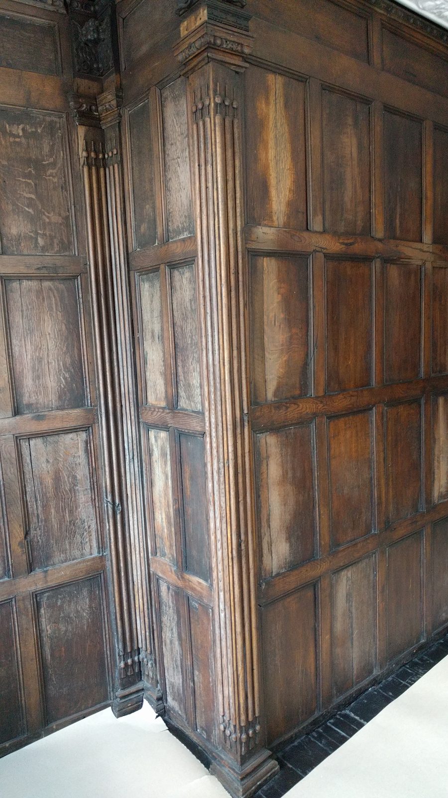 Detail of the oak panelling before tidying, showing faded and bleached panels