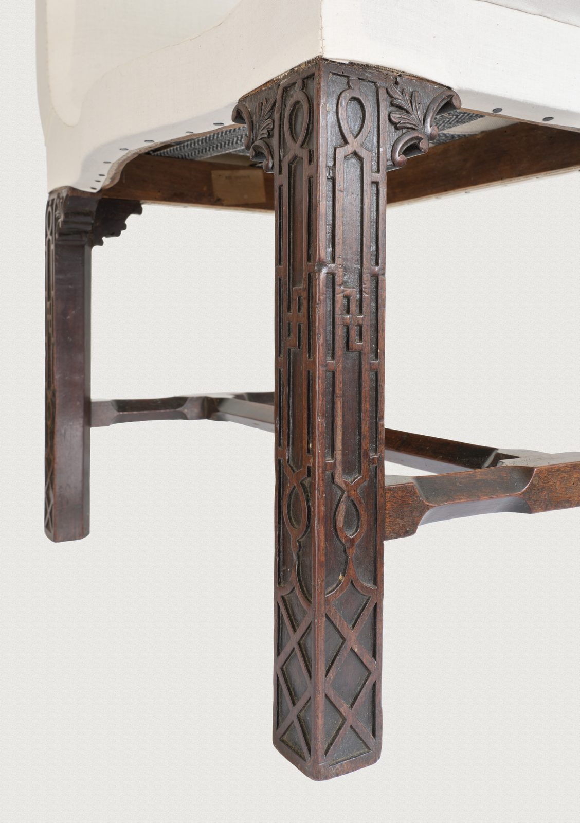 Detail of blind fretwork carved in the solid on a mahogany window seat leg