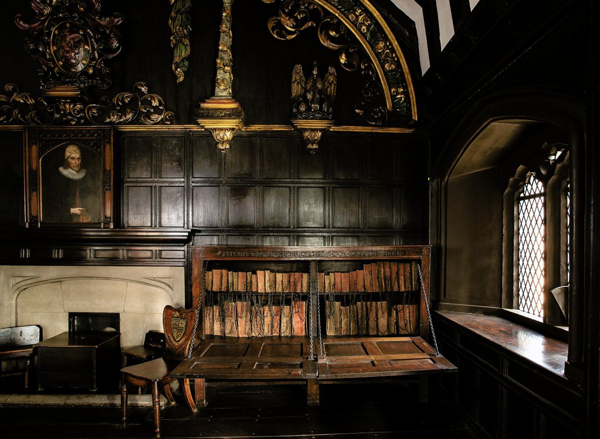 Chained library cabinet in a panelled historic interior at Gorton